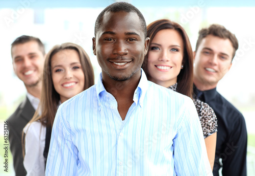 Photo: Group of friendly businesspeople with male leader in front Group of friendly businesspeople with male leader in front