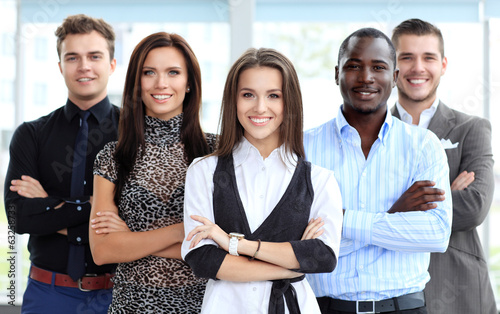 Photo: female business leader standing in front of her team female business leader standing in front of her team