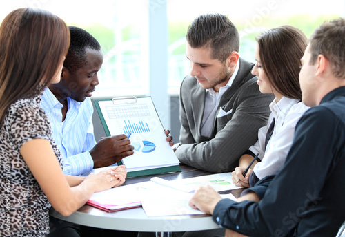 Photo: business partners discussing documents and ideas at meeting business partners discussing documents and ideas at meeting