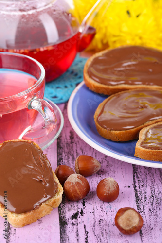 Photo: Bread with sweet chocolate hazelnut spread on plate on table Bread with sweet chocolate hazelnut spread on plate on table