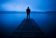 Man Standing on a Jetty by Tranquil Lake Man Standing on a Jetty by Tranquil Lake