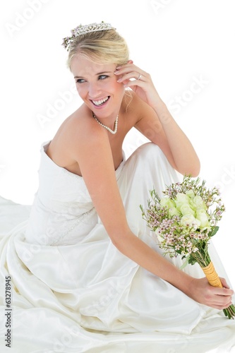 Photo: Bride holding bouquet while looking away Bride holding bouquet while looking away