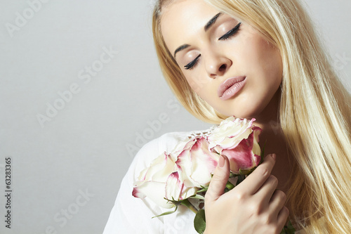 Photo: Beautiful Woman with Flowers.girl and roses. Blond Beautiful Woman with Flowers.girl and roses. Blond