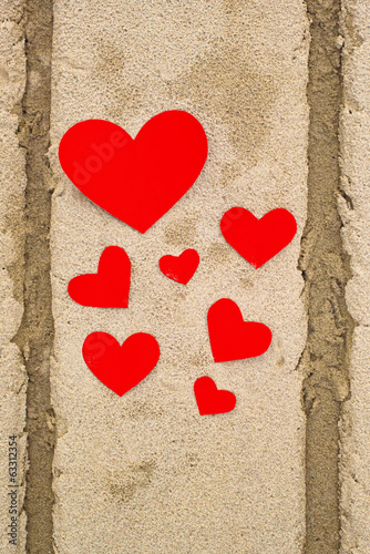 Photo: Red paper hearts in beach sand Red paper hearts in beach sand