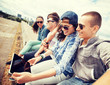 group of teenagers looking at tablet pc group of teenagers looking at tablet pc