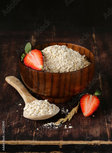 Photo: organic oat flakes with strawberries on a wooden table organic oat flakes with strawberries on a wooden table