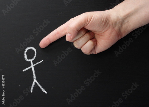 Photo: Giant Hand pointing at stick figure on a blackboard Giant Hand pointing at stick figure on a blackboard
