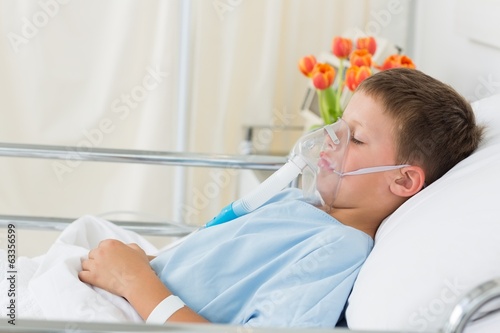 Photo: Sick boy wearing oxygen mask in hospital Sick boy wearing oxygen mask in hospital