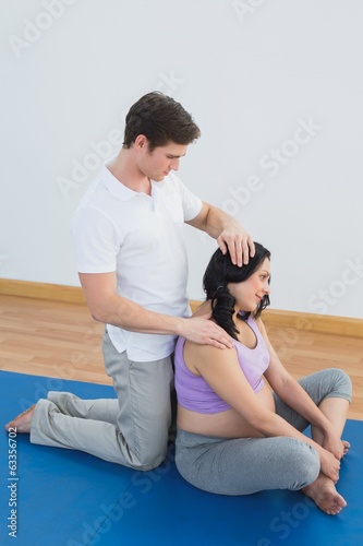 Photo: Masseur massaging pregnant womans shoulder and neck Masseur massaging pregnant womans shoulder and neck