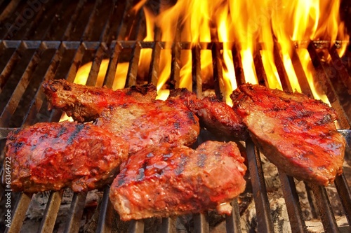 Photo: eef Steak on the BBQ Grill with flames. eef Steak on the BBQ Grill with flames.