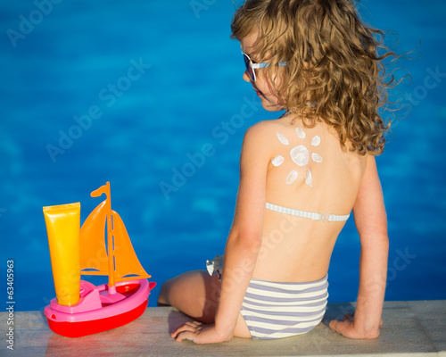 Photo: Sunscreen lotion sun drawing on childrens back Sunscreen lotion sun drawing on childrens back