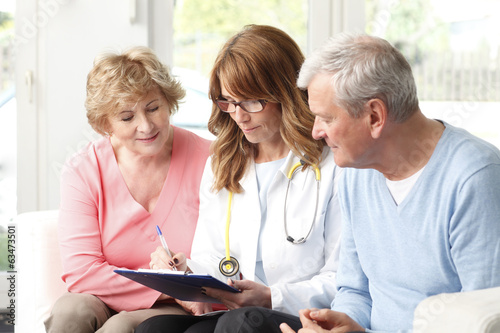 Photo: Elderly couple consulting with female doctor Elderly couple consulting with female doctor