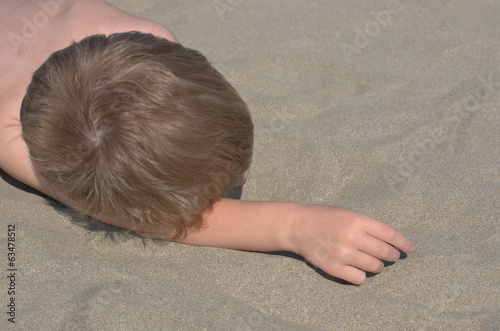 Photo: little boy lying on the sand little boy lying on the sand