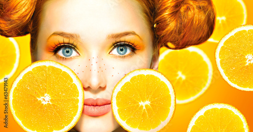 Photo: Beauty model girl with juicy oranges. Freckles Beauty model girl with juicy oranges. Freckles