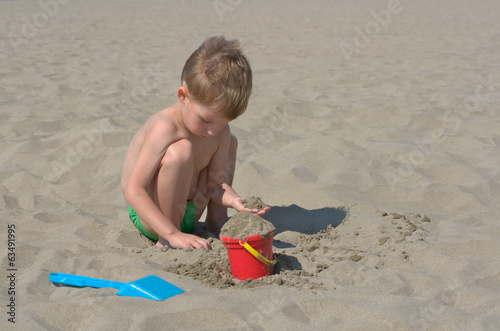 Photo: little boy playing with sand little boy playing with sand
