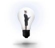 Businesswoman holding tablet in light bulb Businesswoman holding tablet in light bulb