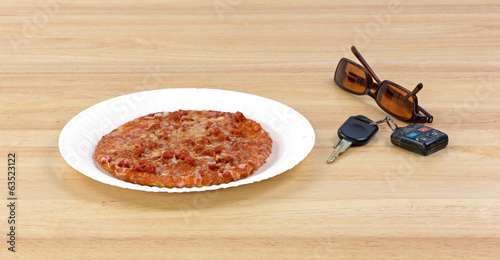 Photo: Pizza next to car keys and sunglasses Pizza next to car keys and sunglasses