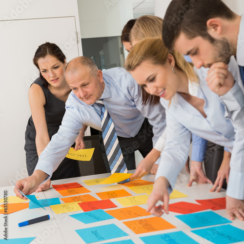 Photo: Business Colleagues Arranging Labels On Table Business Colleagues Arranging Labels On Table