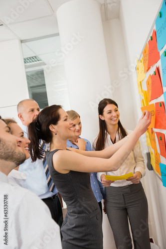 Photo: Businesswoman Sticking Labels On Whiteboard Businesswoman Sticking Labels On Whiteboard