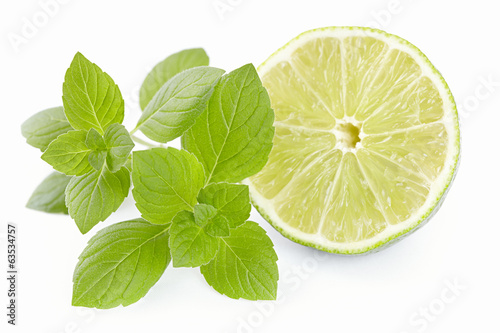 Photo: Limes with a mint branch on the isolated white background Limes with a mint branch on the isolated white background