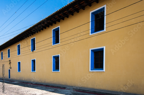Photo: Yellow painted townhouse with blue windows Yellow painted townhouse with blue windows