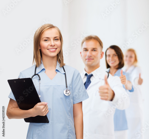 Photo: smiling female doctor or nurse with clipboard smiling female doctor or nurse with clipboard