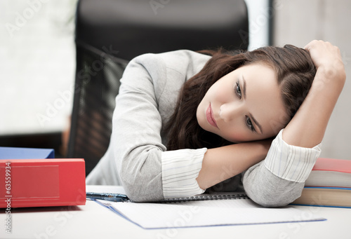 Photo: bored and tired woman behid the table bored and tired woman behid the table