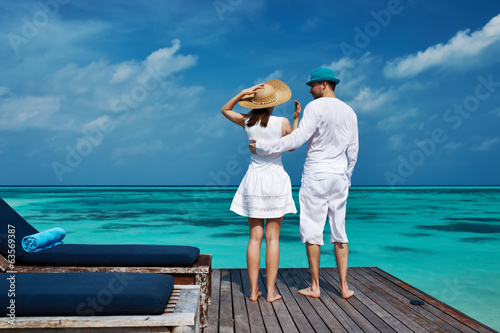 Photo: Couple on a beach jetty at Maldives Couple on a beach jetty at Maldives
