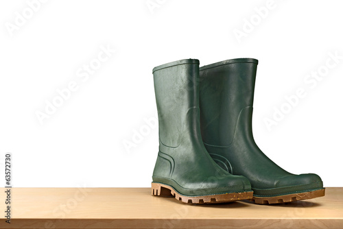 Photo: Green rubber boots on white background Green rubber boots on white background