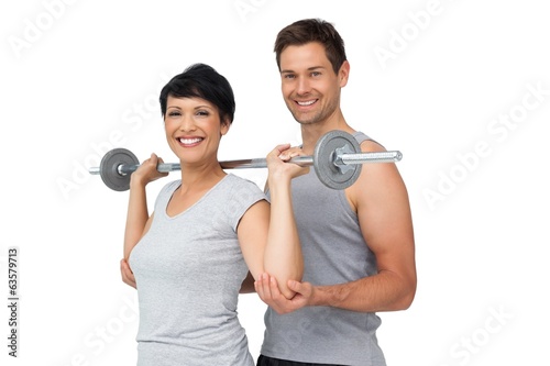 Photo: Personal trainer helping woman with weight lifting bar Personal trainer helping woman with weight lifting bar