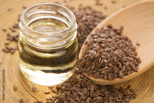 Photo: Linseed oil and flax seeds on wooden background Linseed oil and flax seeds on wooden background