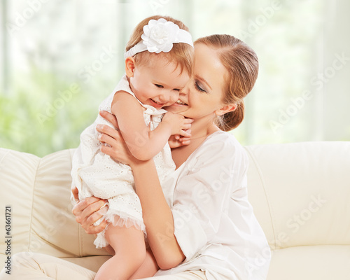 Photo: happy family. Mother and baby daughter plays, hugging, kissing happy family. Mother and baby daughter plays, hugging, kissing