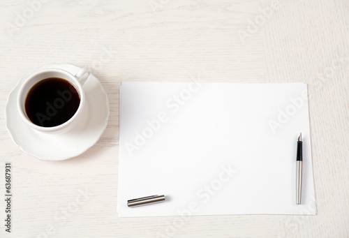 Photo: Blank paper and pen on wooden table Blank paper and pen on wooden table