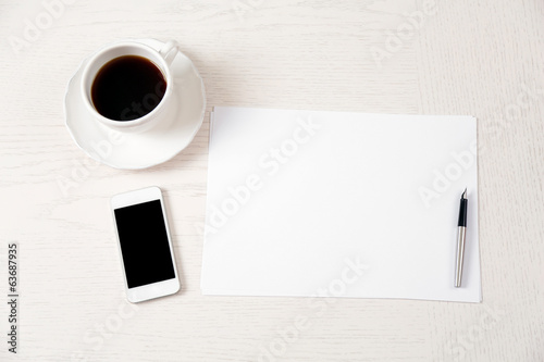 Photo: Blank paper and pen on wooden table Blank paper and pen on wooden table