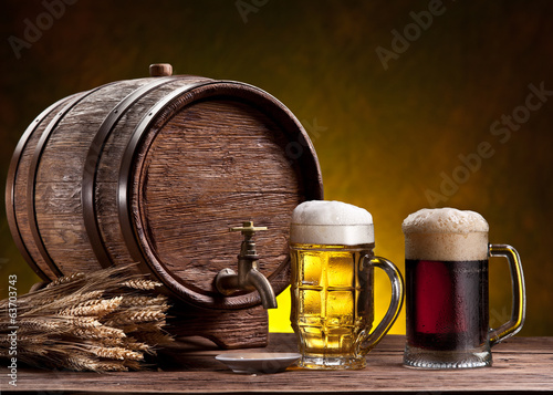 Photo: Beer glasses, old oak barrel and wheat ears. Beer glasses, old oak barrel and wheat ears.