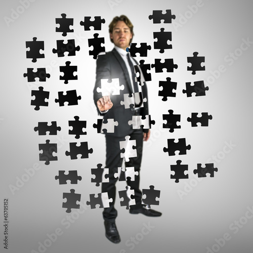 Photo: Businessman selecting a puzzle piece Businessman selecting a puzzle piece
