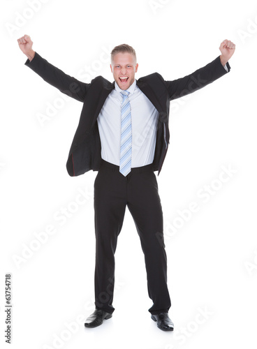 Photo: Young businessman in a suit standing cheering Young businessman in a suit standing cheering