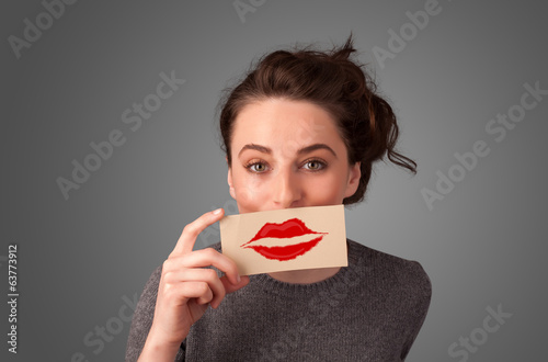 Photo: Happy pretty woman holding card with kiss lipstick mark Happy pretty woman holding card with kiss lipstick mark