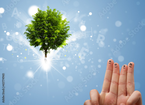 Photo: Happy finger smileys with green magical glowing tree Happy finger smileys with green magical glowing tree