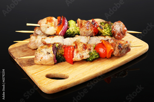 Photo: Pork kebab on black background Pork kebab on black background