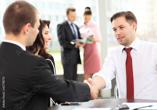 Photo: Business people shaking hands, finishing up a meeting Business people shaking hands, finishing up a meeting