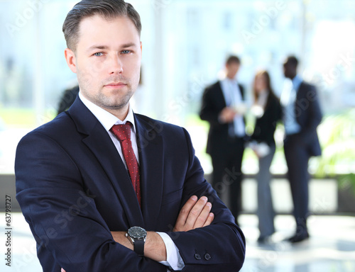 Photo: Image of cross-armed leader in working environment Image of cross-armed leader in working environment
