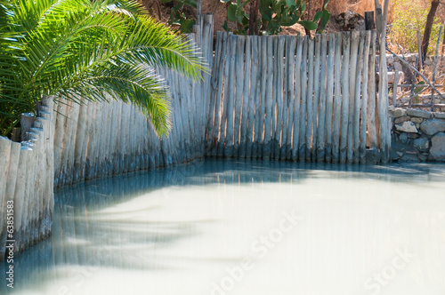 Photo: Therapeutic mud bath, surrounded by a wooden fence Therapeutic mud bath, surrounded by a wooden fence