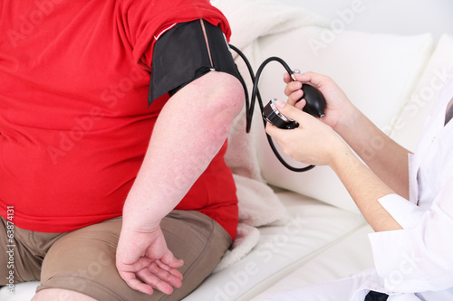 Photo: Doctor examining patient obesity on light background Doctor examining patient obesity on light background