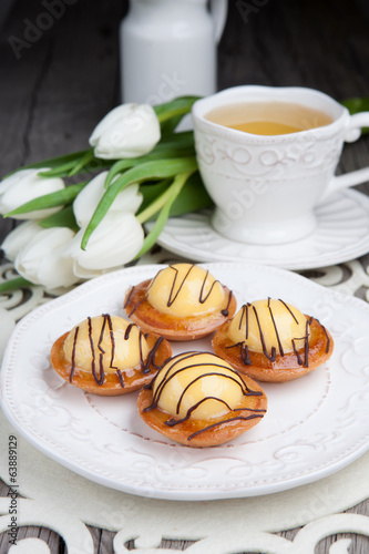 Photo: Sweet cake with cup of tea on wooden table Sweet cake with cup of tea on wooden table