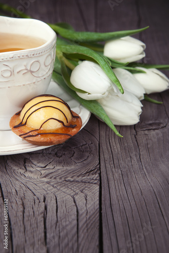 Photo: Sweet cake with cup of tea on wooden table Sweet cake with cup of tea on wooden table
