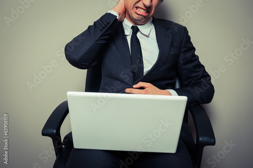 Photo: Businessman with neck pain Businessman with neck pain