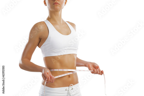Photo: young athletic woman measuring waist young athletic woman measuring waist