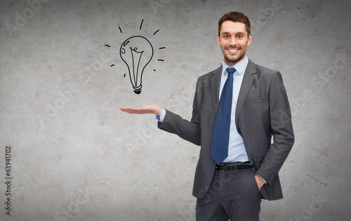 Photo: man showing light bulb on the palm of his hand man showing light bulb on the palm of his hand