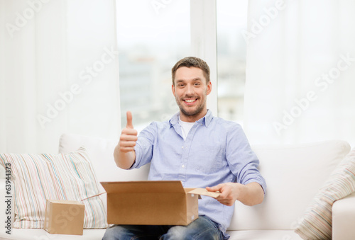 Photo: man with cardboard boxes at home showing thumbs up man with cardboard boxes at home showing thumbs up